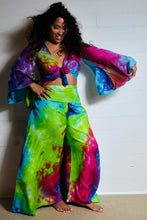 Load image into Gallery viewer, Emma's Emporium tie dye Palazzo trousers, extra wide leg flared hippy trousers with wide elastic waistband in bright vibrant tie dye. Made to ethical fair trade standards for Emma's Emporium slow fashion alternative women's festival clothing.