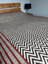 Load image into Gallery viewer, Emma's Emporium king size bedspread with a black chevron pattern on a natural unbleached heavy cotton background, displayed on a bed.