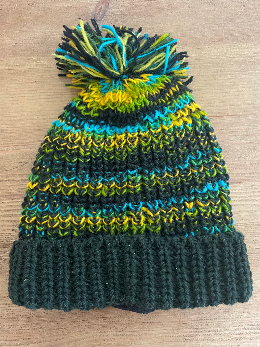 Buy now online from Emma's Emporium, Colourful Nepalese Rainbow Pompom Bobble Hat! Keep your head warm this winter! Pure wool hand knitted hats in vibrant rainbow colours. Made for Emma's Emporium with love by our friends in Kathmandu.