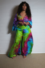 Load image into Gallery viewer, Emma&#39;s Emporium tie dye Palazzo trousers, extra wide leg flared hippy trousers with wide elastic waistband in bright vibrant tie dye. Made to ethical fair trade standards for Emma&#39;s Emporium slow fashion alternative women&#39;s festival clothing.
