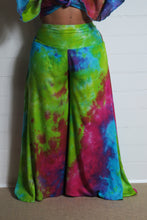 Load image into Gallery viewer, Emma&#39;s Emporium tie dye Palazzo trousers, extra wide leg flared hippy trousers with wide elastic waistband in bright vibrant tie dye. Made to ethical fair trade standards for Emma&#39;s Emporium slow fashion alternative women&#39;s festival clothing.
