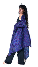 Load image into Gallery viewer, A woman modeling a long, draped shawl with a blue and purple paisley pattern, styled over a black top and black wide-leg pants against a solid white background. Emma's Emporium paisley fleece blanket cardigan wrap throw. Shop online and buy now ethical slow fashion, unisex, men's, women's boho festival clothing.
