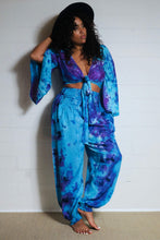 Load image into Gallery viewer, Genie Trousers! Photo of model in Emma&#39;s Emporium tie dye Genie harem trousers, low crotch hippy trousers with wide elastic waistband on bright vibrant tie dye. Made to ethical fair trade standards for Emma&#39;s Emporium slow fashion alternative women&#39;s festival clothing.
