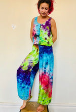 Load image into Gallery viewer, Genie Trousers! Photo of model in Emma&#39;s Emporium tie dye Genie harem trousers, low crotch hippy trousers with wide elastic waistband on bright vibrant tie dye. Made to ethical fair trade standards for Emma&#39;s Emporium slow fashion alternative women&#39;s festival clothing.
