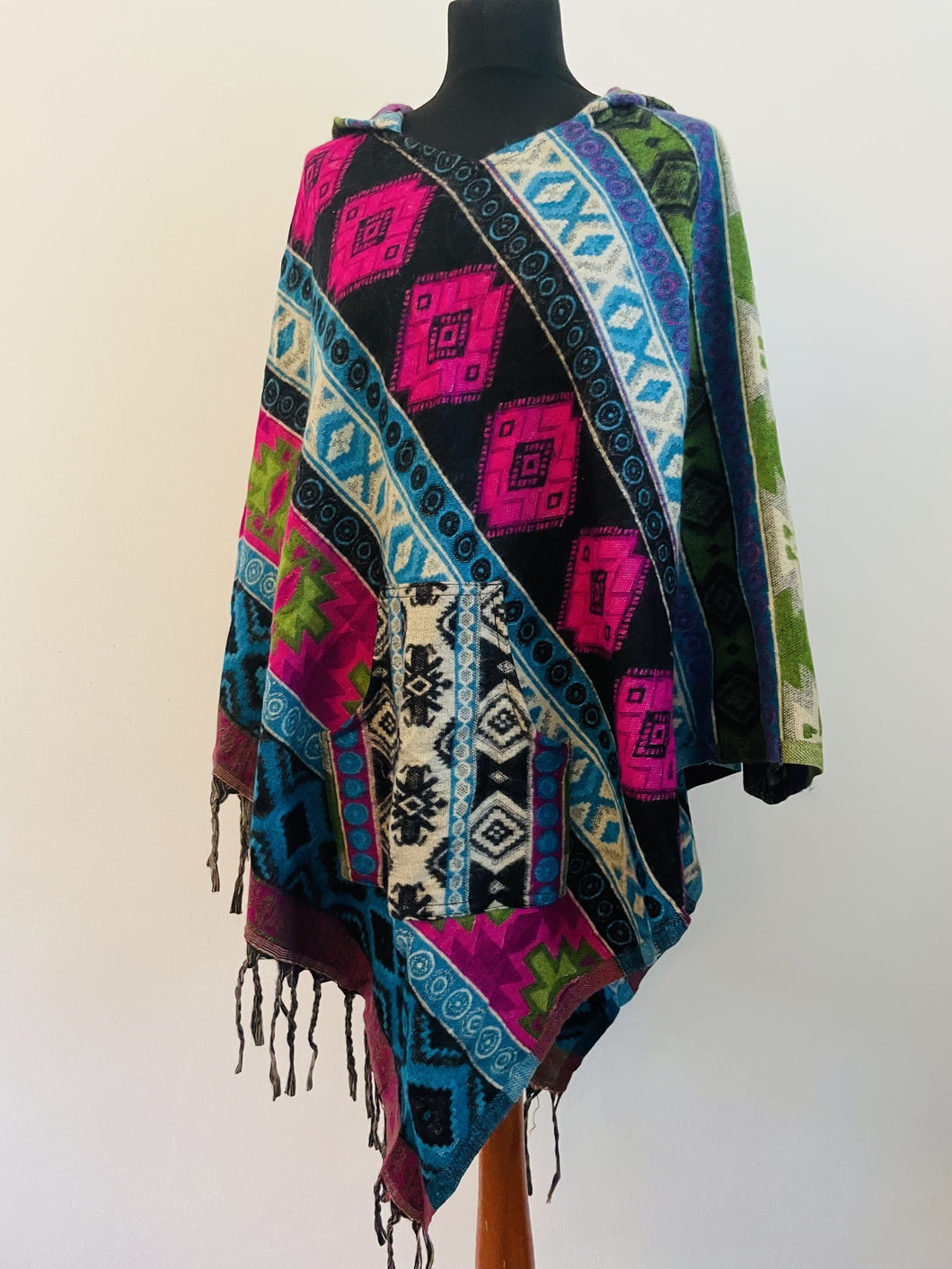 Colourful geometric fleecy warm hippie fair-trade poncho, with front pocket, unisex gender neutral clothing made from vegan wool.